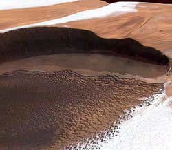 Dark, rippling dunes may have formed from ash that surfaced from underground volcanic activity or crumbled off ancient layered deposits 