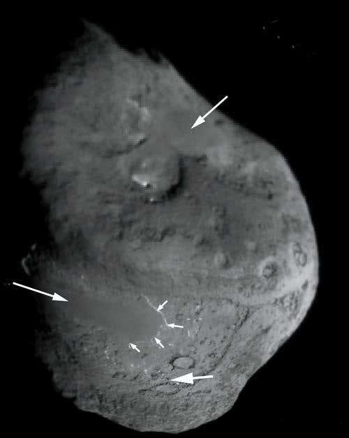 This composite image, taken by the impactor targeting sensor on Deep Impact, shows two areas (arrowed) where the surface is smooth instead of spotted with depressions 