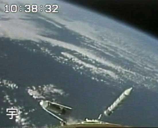 Five minutes after launch, a spent solid rocket booster falls from the H-IIA launcher 