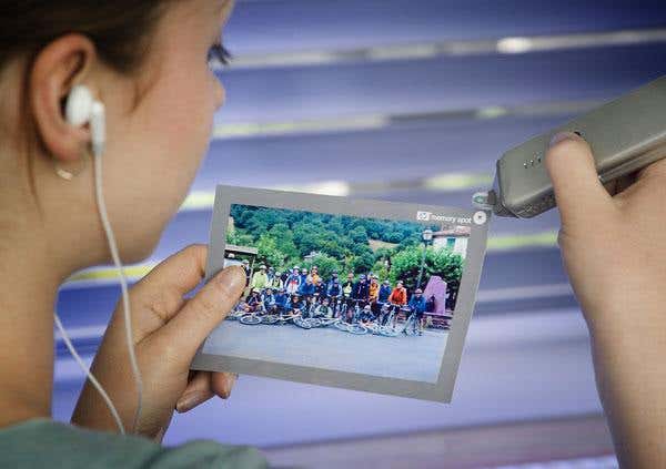 A prototype Memory Spot reader accesses video, music and text from a chip embedded in a photo 