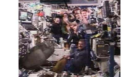 The crews of the space shuttle and the International Space Station gather in the station's Destiny lab after docking on Monday
