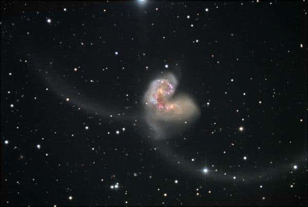 The two Antennae galaxies were once stately spirals and have been deformed by their interaction, creating the long tails seen in this ground-based image