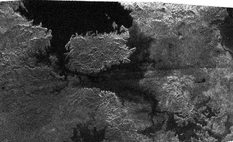 Dark features thought to be lakes of liquid methane appear in this radar image of Titan, including one containing a large island