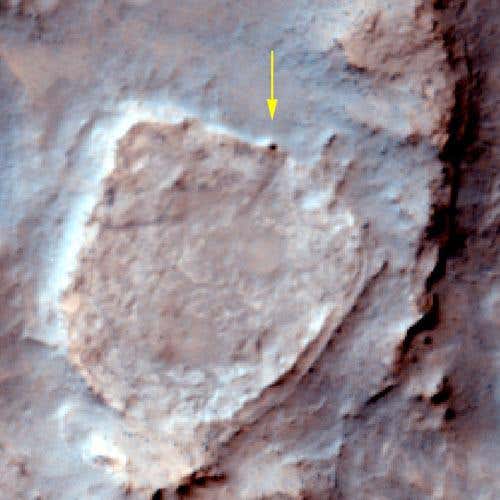 The Spirit rover (dark spot marked with arrow) spent the winter parked on the northern edge of a volcanic plateau called Home Plate