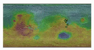 In this global elevation map (where blue is low and red is high), small green circles show where CRISM detected carbonates on Mars (Illustration: Ehlmann et al./Science)