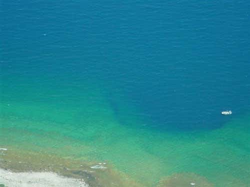 The shallow Middle Island sinkhole can be seen from the surface; a 9-metre boat provides the scale of the hole