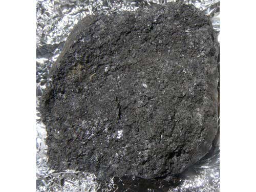 The recovered bits of asteroid 2008 TC3, like the meteorite shown here, typically have a dark, scruffy texture. They are eurelites, a type of meteroite that is only partially melted. By comparing the spectrum of the meteorites with observations of 2008 TC3 while it was still approaching Earth, astronomers can now link eurelites with dark, F-class asteroids. This is the first time rocks that have fallen to Earth have been definitively matched up with a particular class of parent asteroids