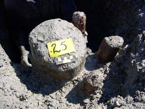 This close-up shows a structural house post, and its supporting posts, in situ following partial excavation 