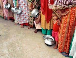 ... while Bangladeshi people queue for scarce food 