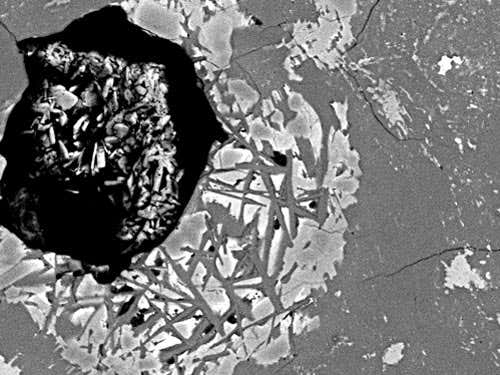 Close-up view of our fragment of Dhofar 458. the large bright area is a result of melting during the impact.