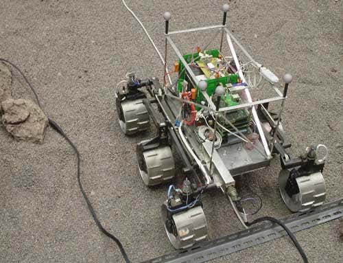 The reflective silver spheres on the top of the rover are tracked by eight cameras overhead as the robotic vehicle tries to find its way around obstacles.