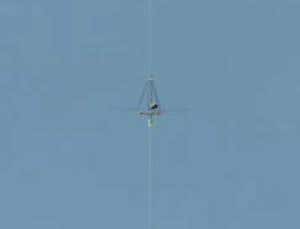 The winning robotic climber ascends the cable, powered by an infrared laser shining on its solar cells