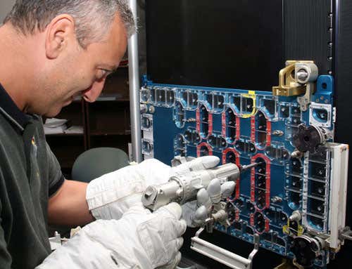 Astronaut Mike Massimino wears space gloves while practising a tricky repair of Hubble's STIS instrument before the final mission to service the telescope last May