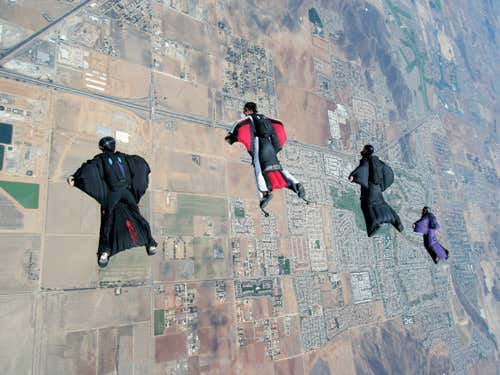 Jeb Corliss (Black suit, right of centre) makes another jump