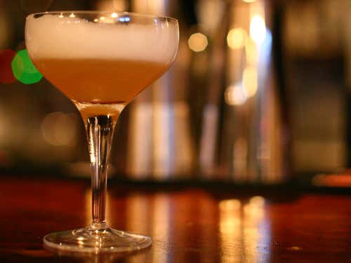 Somerset Sour: Apple brandy, lemon juice, sugar, egg white and a dash of cider, shaken with ice and strained into a glass then garnished with a bobbing apple and a