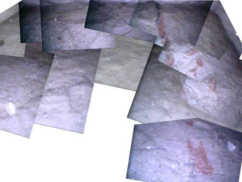 A composite image of the chamber floor behind the first blocking stone showing red figures to the right of a mason's line
