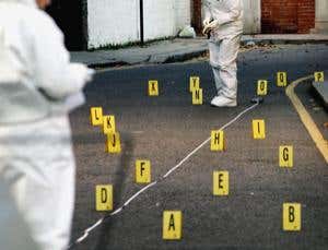Lettered markers on a floor with white-suited people standing around
