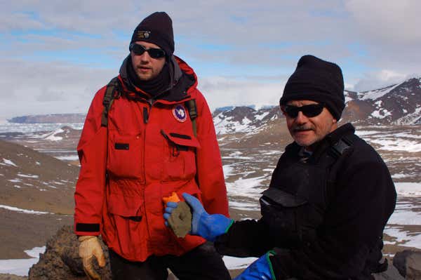 Joe Kirschvink (right) holds a gastropod fossil, Tom Tobin