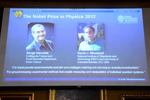 Haroche and Wineland are announced on a screen in Stockholm, Sweden
