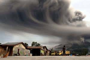 Tower of ash overshadows life beneath erupting volcano