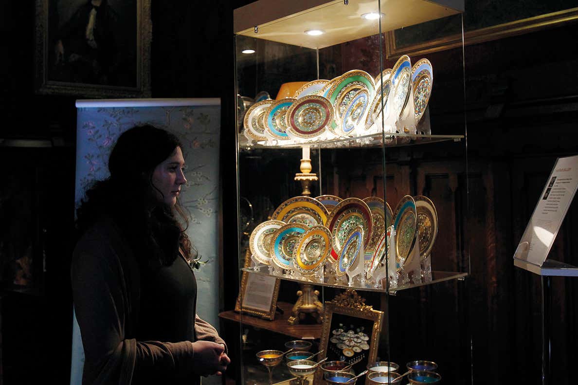 A women observes some China plates in a museum