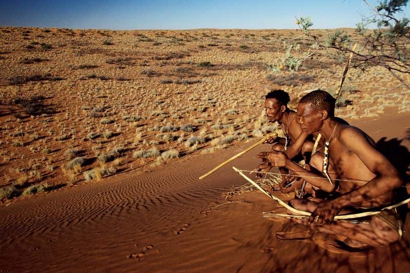 Two men in a desert with bows and arrows