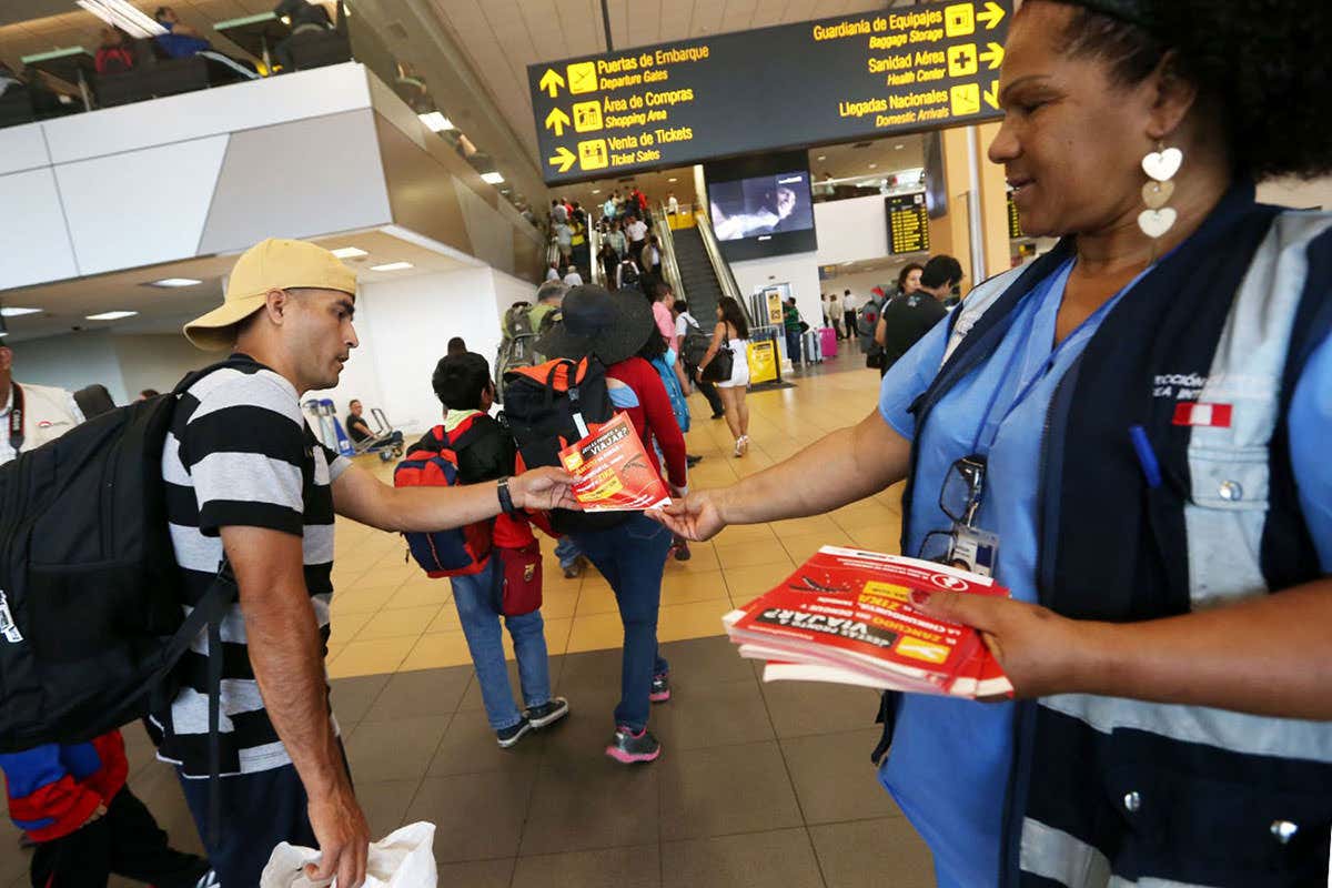 Woman hands out a leaflet on Zika prevention