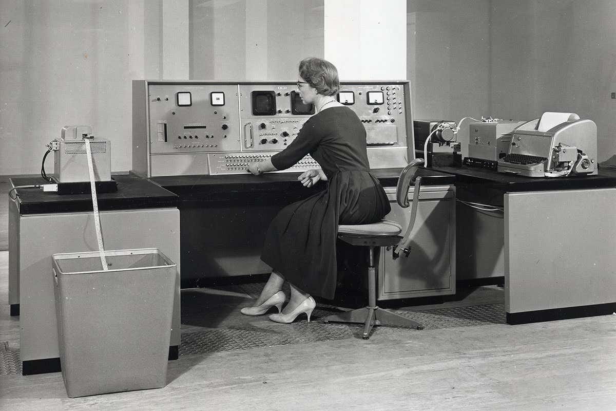 Woman sitting in front of an early office computer