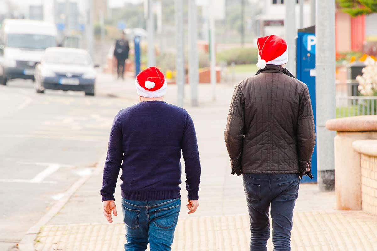 two men walking away down the street wearing santa hats. The connection to the story is marginal