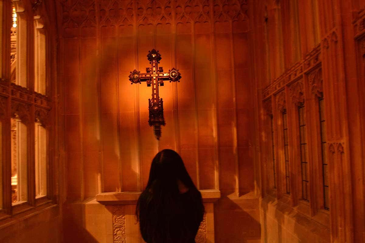 A nun prays at an altar
