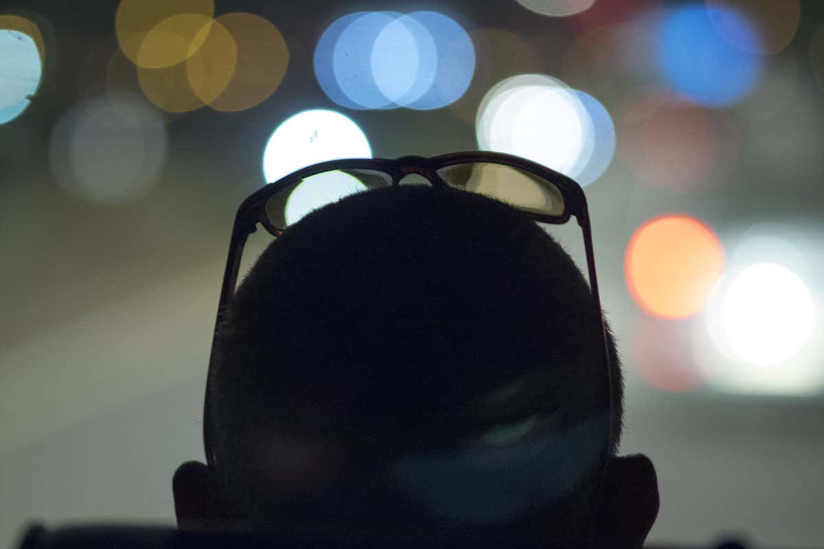 A person gazes into the distance. The background is out of focus