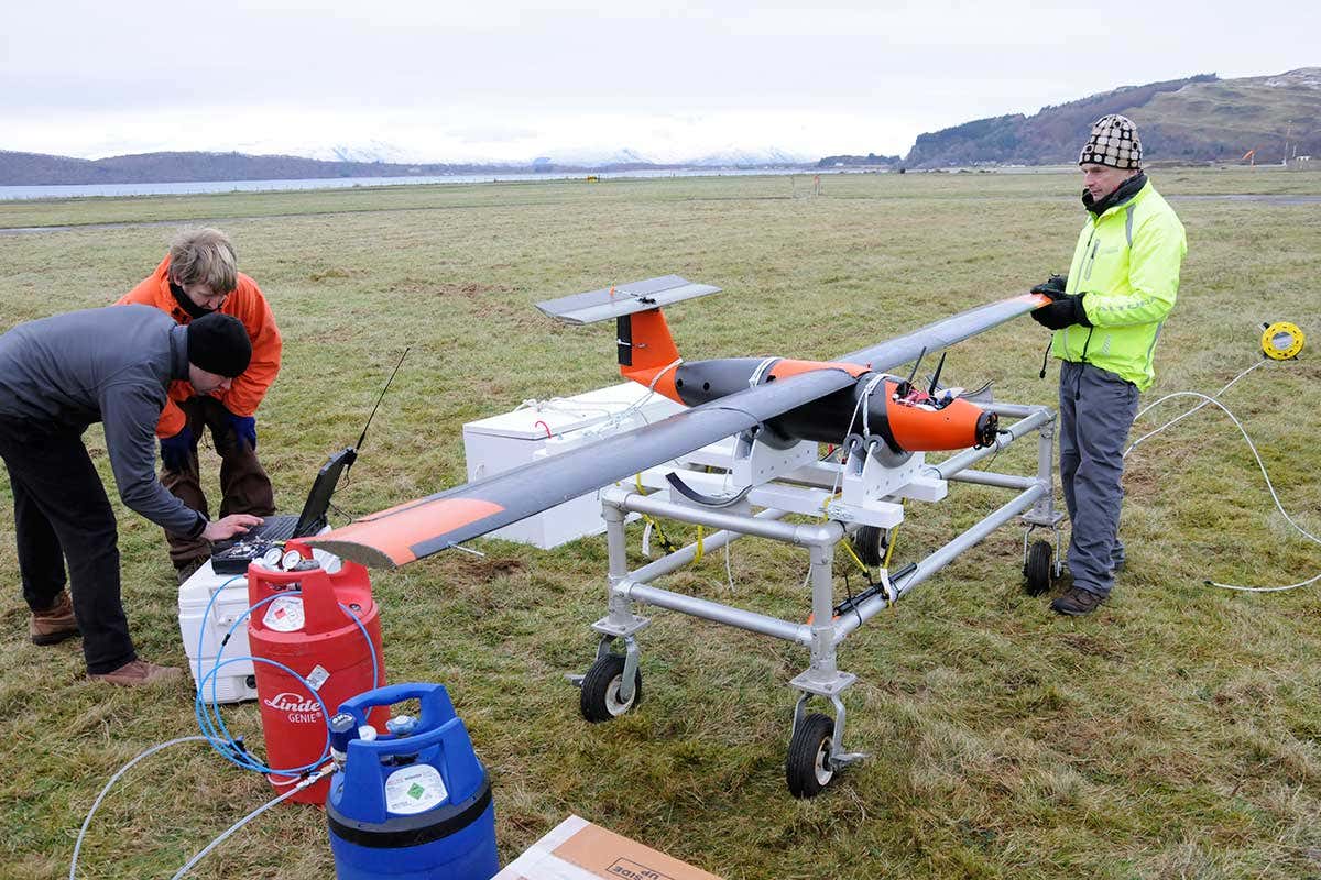 A team prepares the drone in the middle of a field