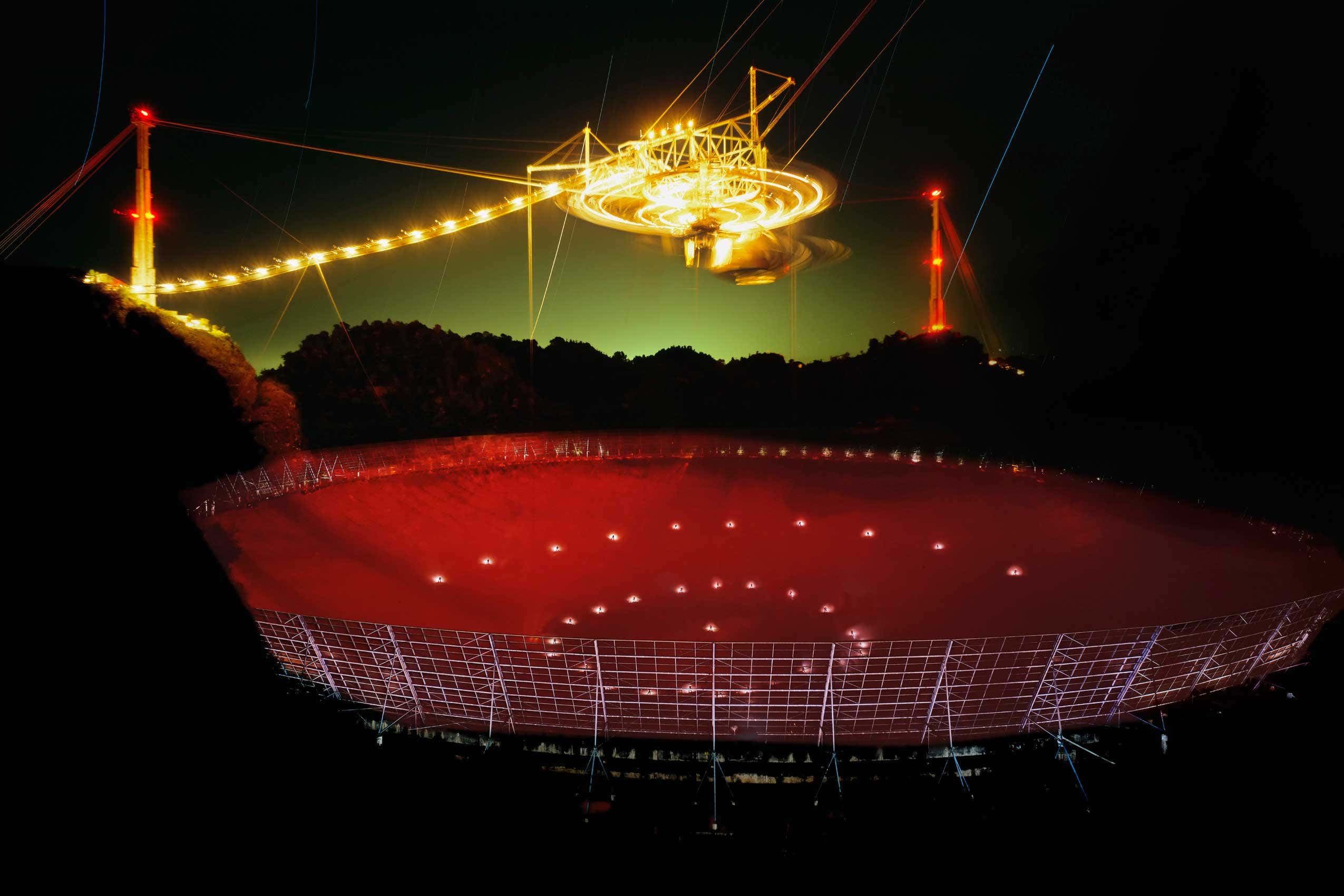 A giant radio telescope illuminated at night