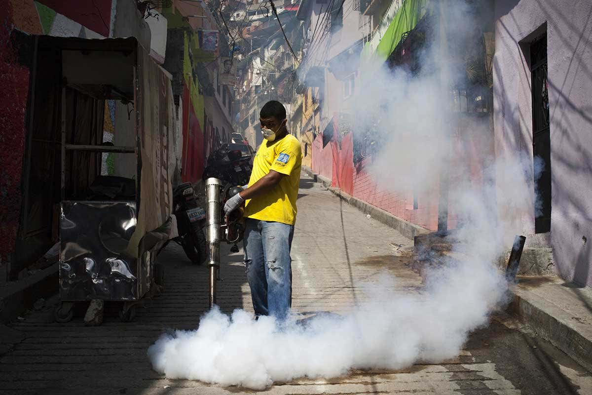 A man spraying mosquito-killing smoke
