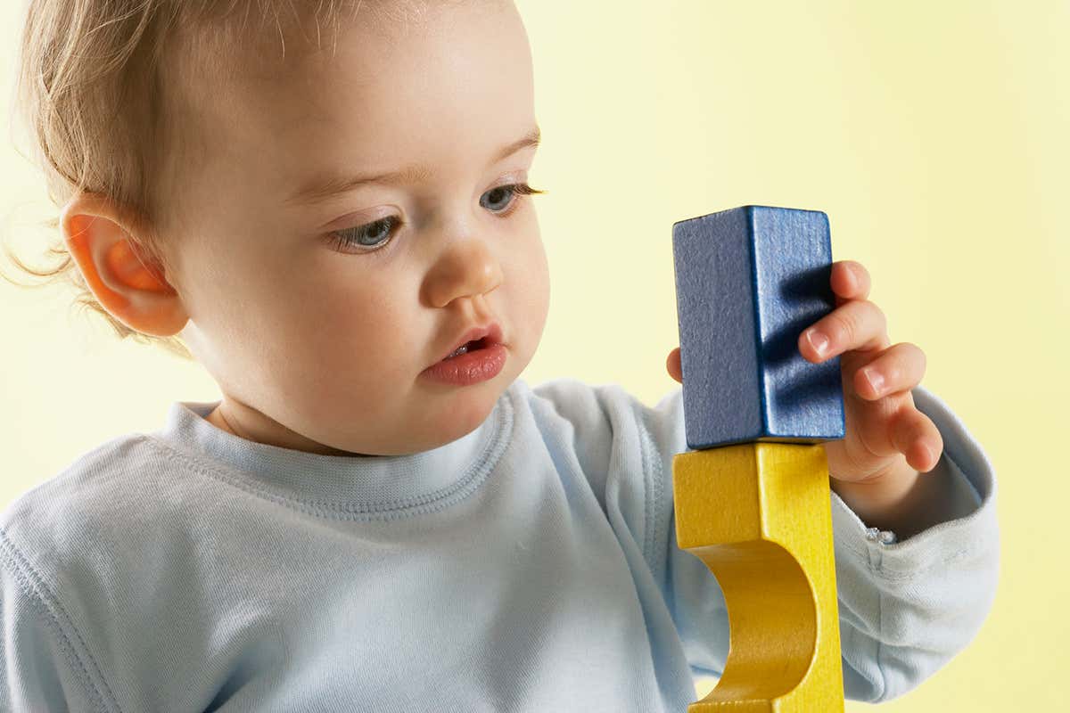 A toddler playing with wooden blocks