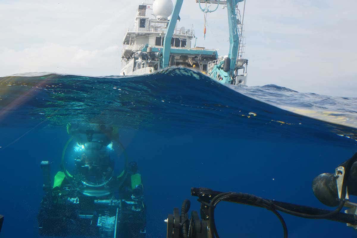 A submersible descends into the water from the surface
