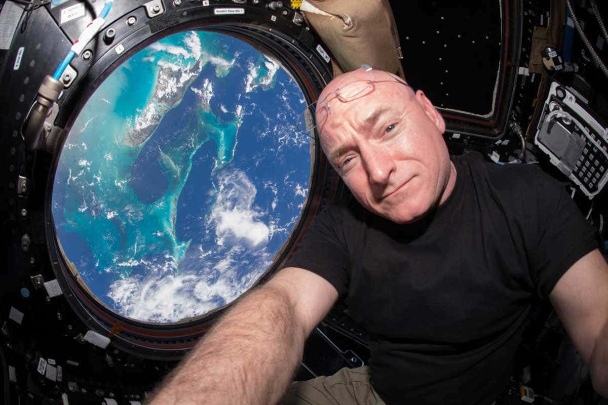 Scott Kelly selfie on the International Space Station, with a view of Earth out the window behind him