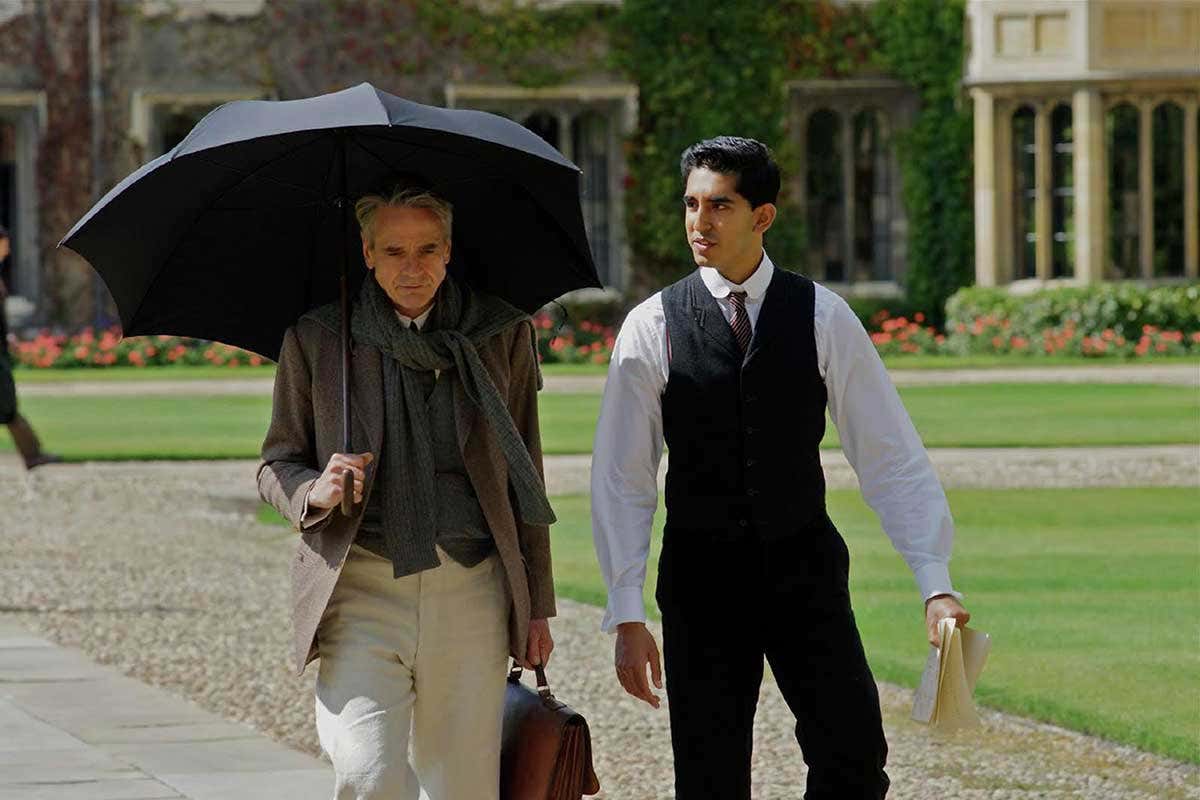 G. H. Hardy (Jeremy Irons) and Srinivasa Ramanujan (Dev Patel) walk together, deep in conversation