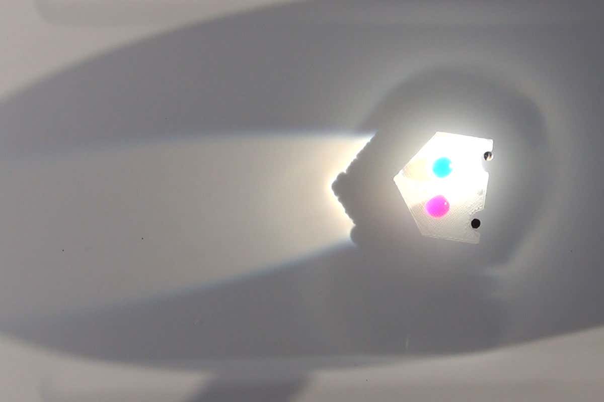 Laser-driven liquid marbles can push 150 times their own weight