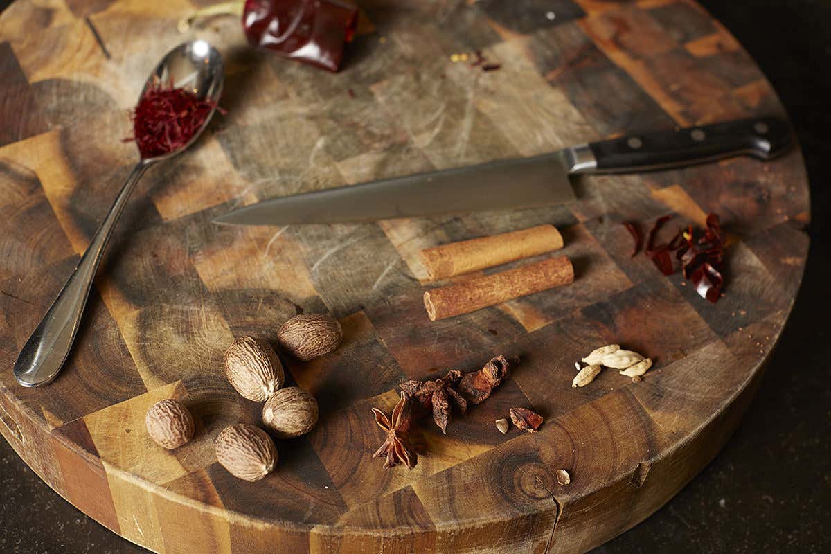 A variety of spices such as nutmeg and saffron are arranged on a table