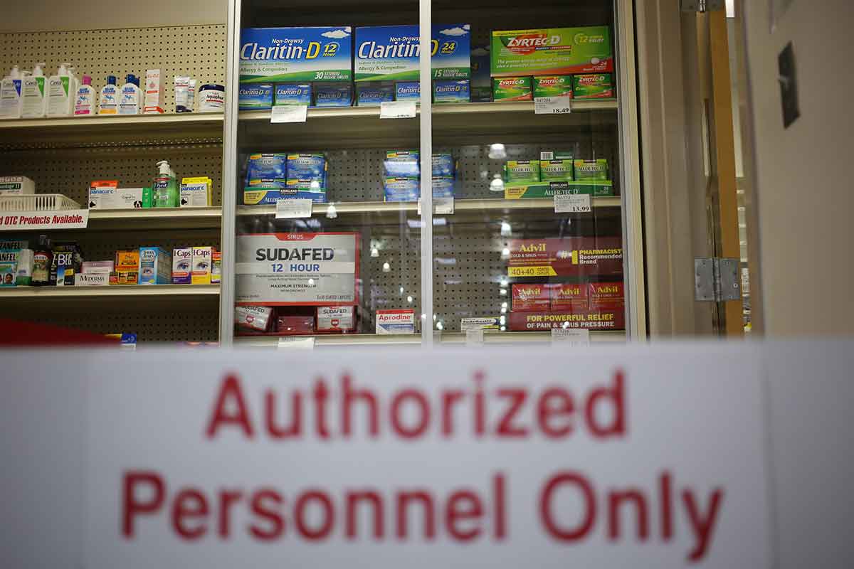 A sign infront of a shelf of cold medicine reads: