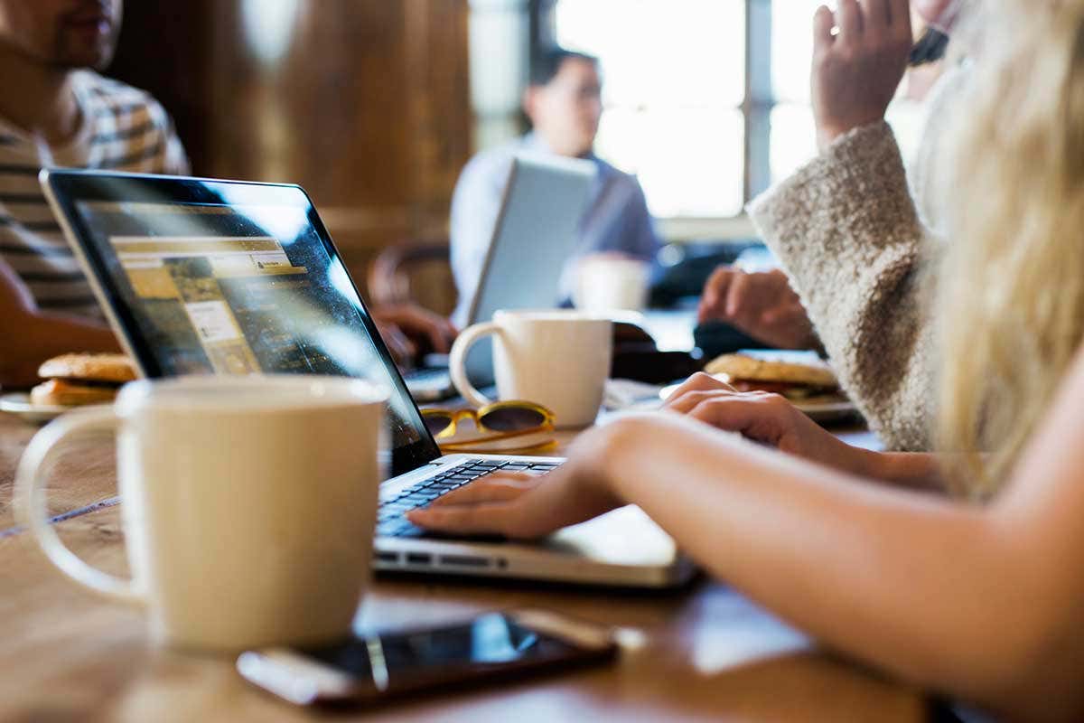 People sit an work on their laptops in a coffee shop