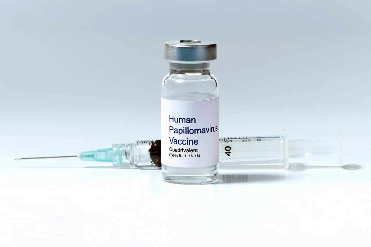 A bottle of the HPV vaccine beside a needle