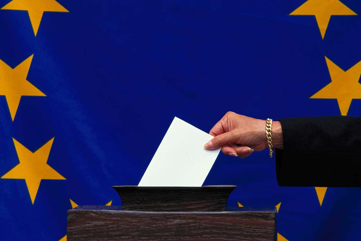 SOmeone voting in front of an EU flag