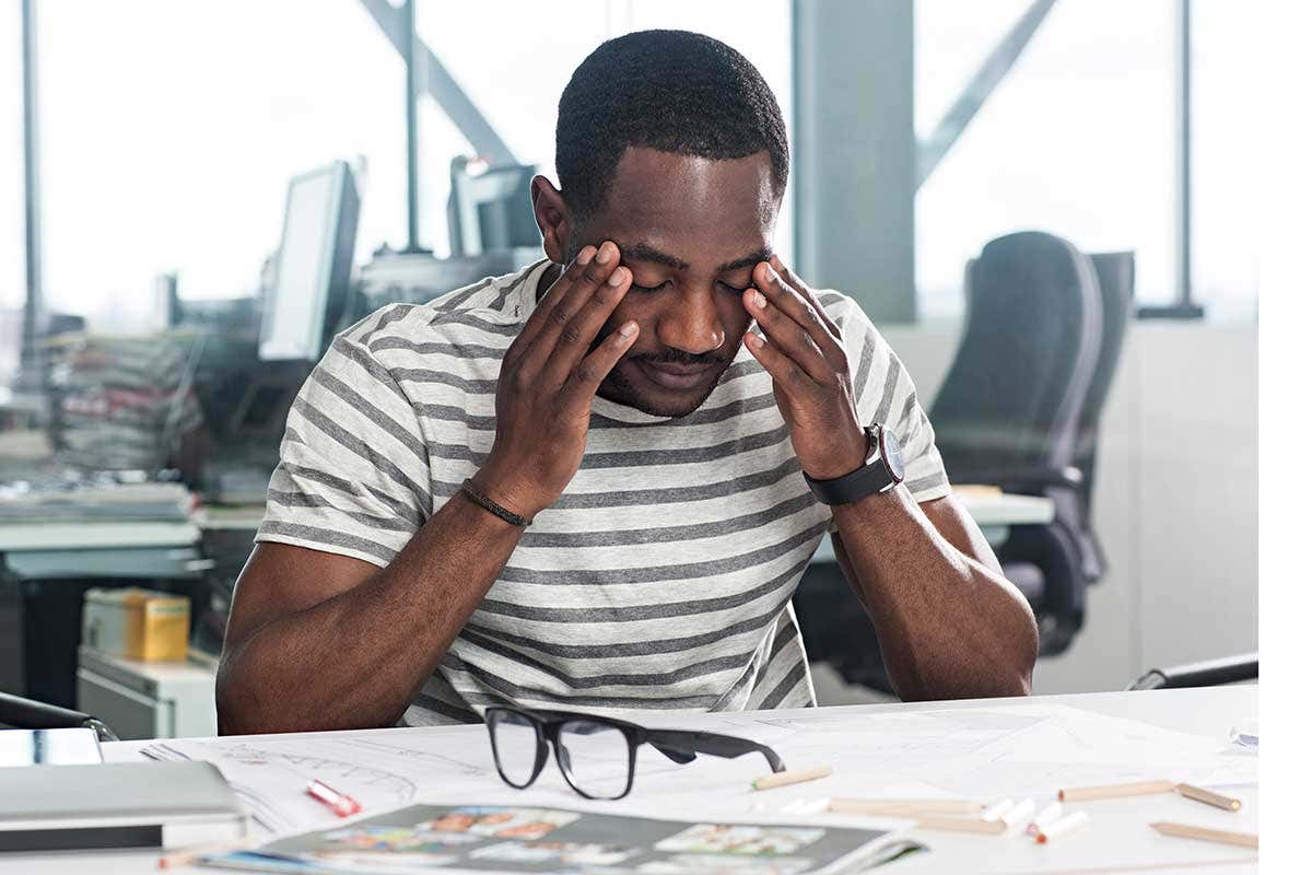 Man with head in his hands looking tired
