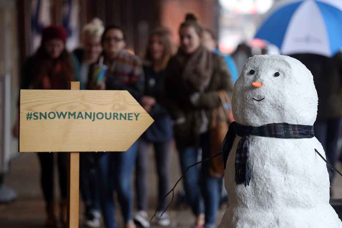 A snowman, with the hashtag snowmannourney on a sign next to it. Part of John Lewis's christmas advertising campaign