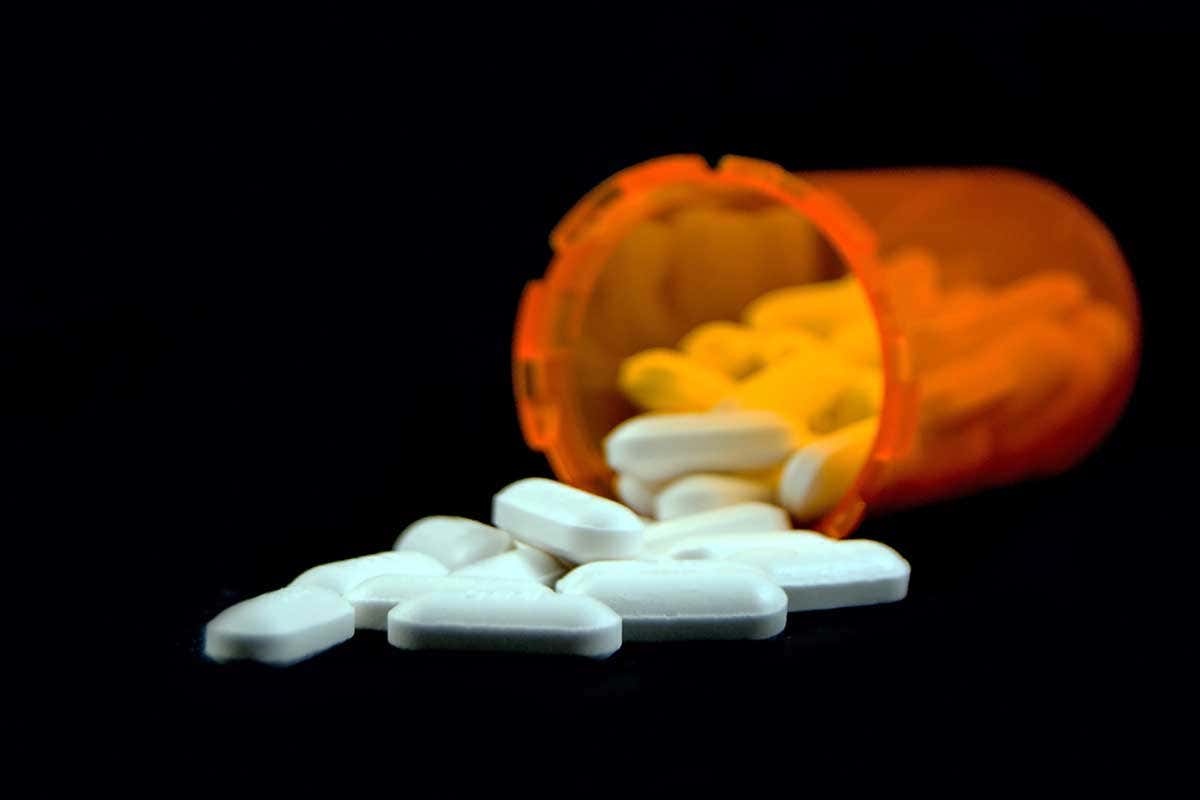 A bottle with pill spilling out