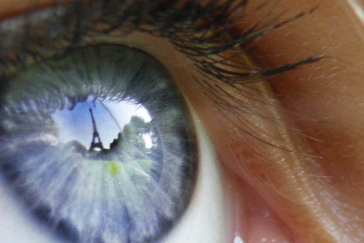 Human eye with Eiffel tower reflected in it
