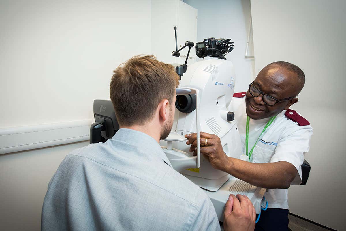 A healthcare professional taking a scan of a person's eye