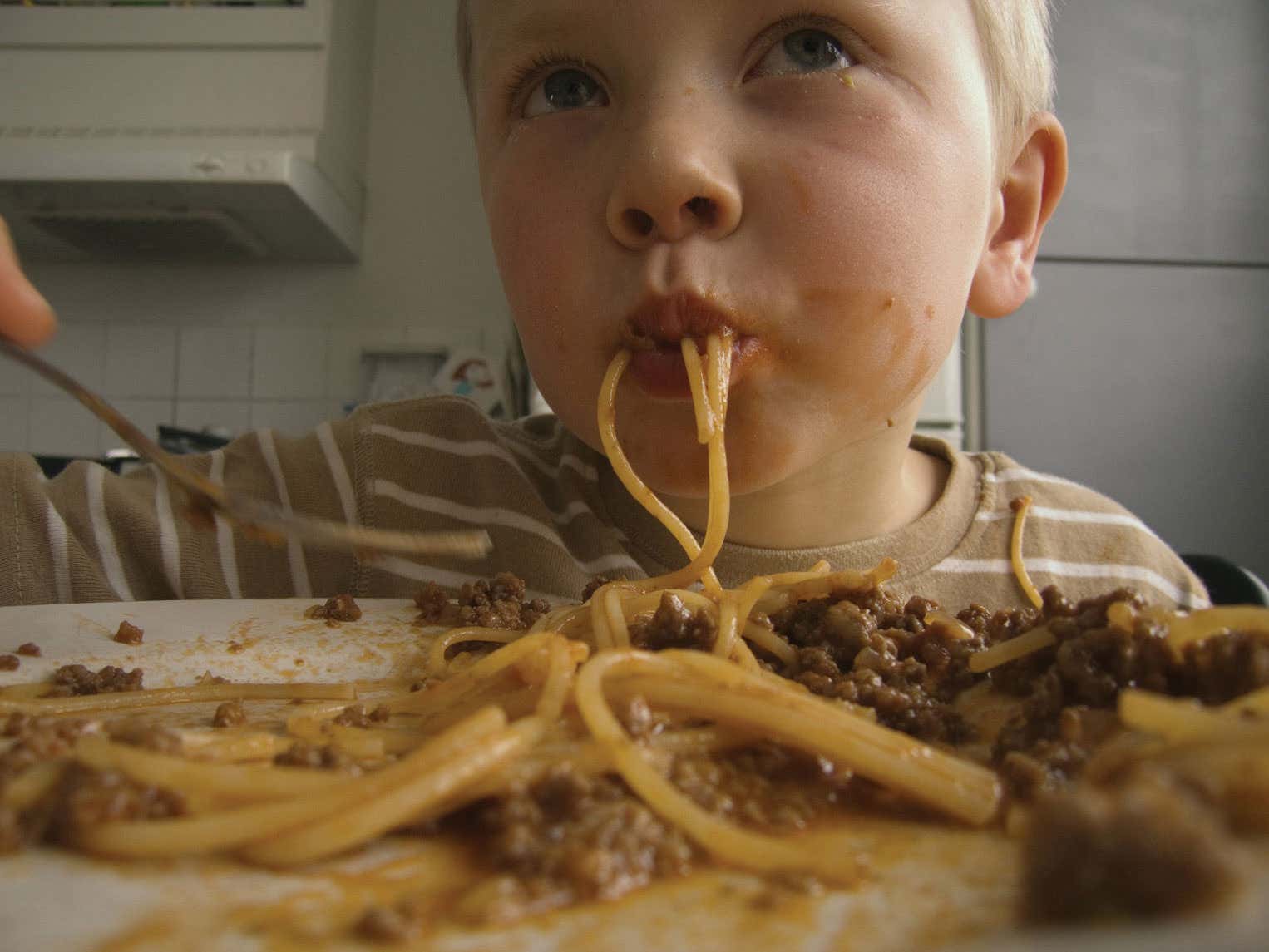 close up of a kid slurping spag bol